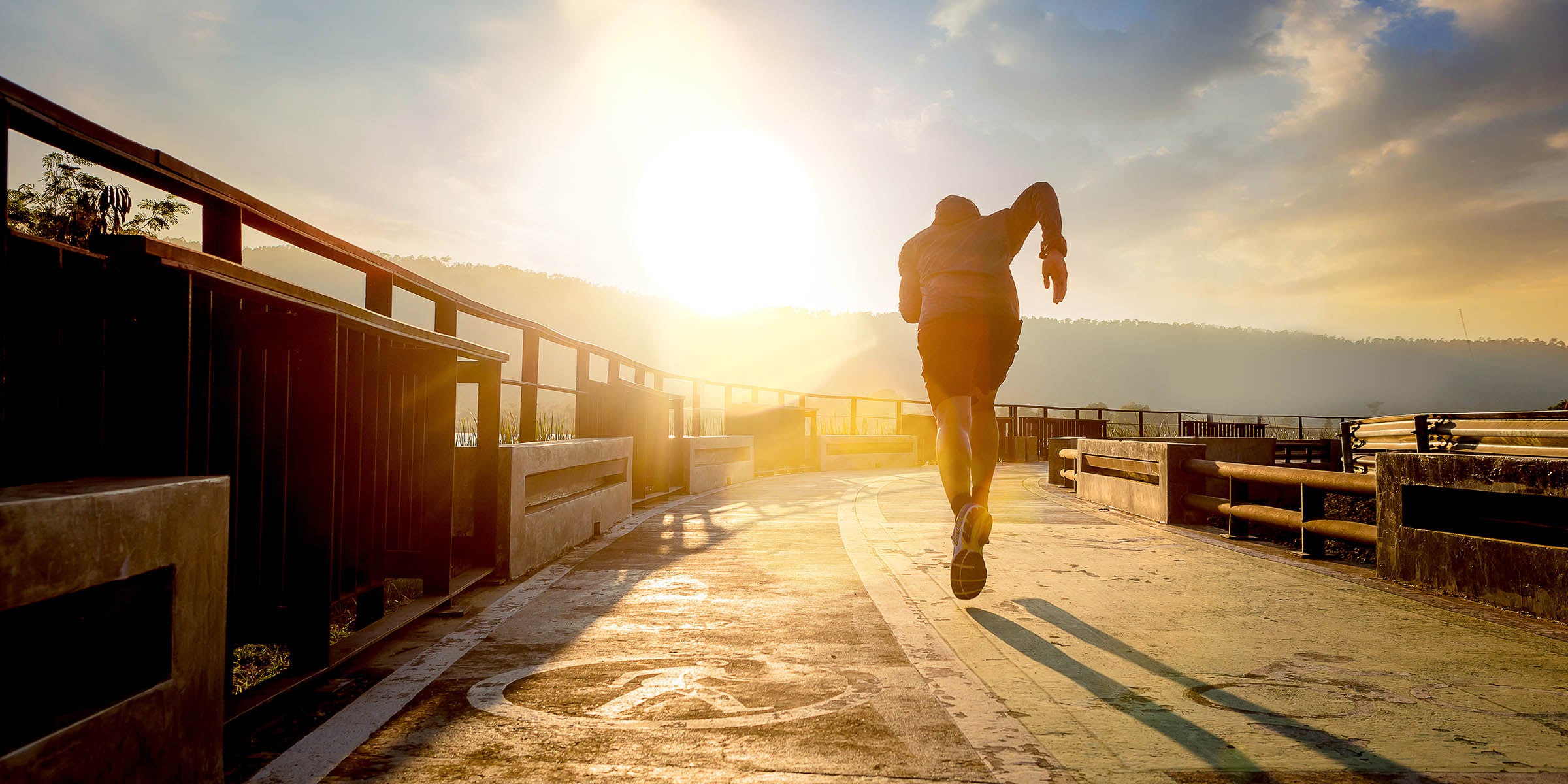 Silhouette of man running on path — athletic motivation, unlock your wellness